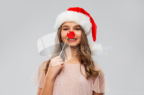 Image of happy teenage girl in santa hat on christmas