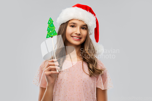 Image of happy teenage girl in santa hat on christmas