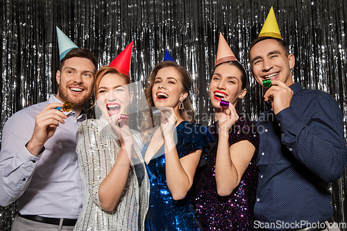 Image of happy couple with party blowers having fun