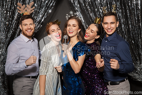 Image of friends with microphone singing at christmas party