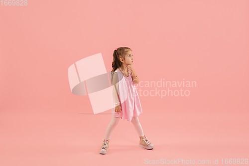 Image of Childhood and dream about big and famous future. Pretty longhair girl isolated on coral pink background