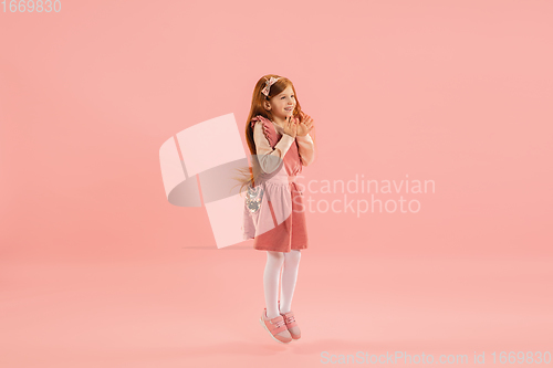 Image of Childhood and dream about big and famous future. Pretty longhair girl isolated on coral pink background