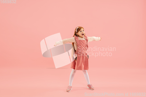 Image of Childhood and dream about big and famous future. Pretty longhair girl isolated on coral pink background