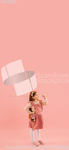 Image of Childhood and dream about big and famous future. Pretty longhair girl isolated on coral pink background