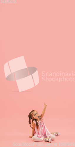 Image of Childhood and dream about big and famous future. Pretty longhair girl isolated on coral pink background