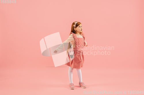 Image of Childhood and dream about big and famous future. Pretty longhair girl isolated on coral pink background