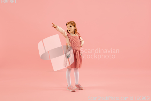 Image of Childhood and dream about big and famous future. Pretty longhair girl isolated on coral pink background