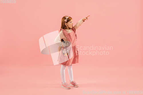 Image of Childhood and dream about big and famous future. Pretty longhair girl isolated on coral pink background