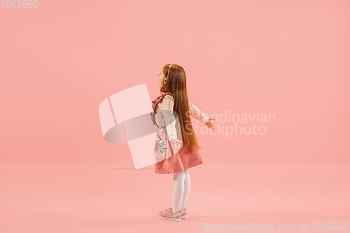 Image of Childhood and dream about big and famous future. Pretty longhair girl isolated on coral pink background