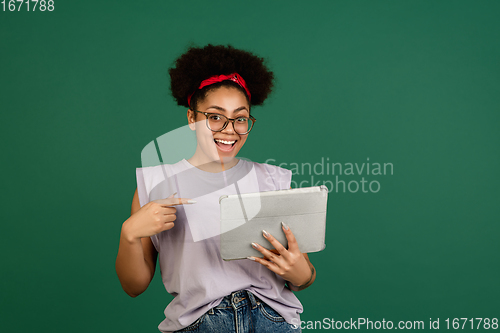 Image of African-american woman\'s portrait isolated on green studio background with copyspace