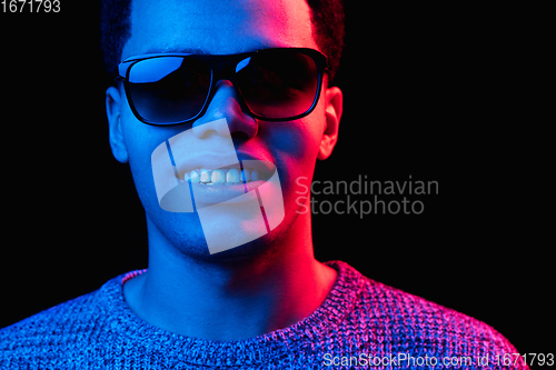 Image of African-american man\'s portrait isolated on black studio background in multicolored neon light
