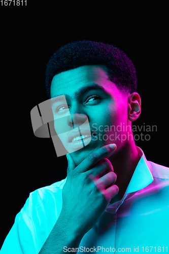 Image of African-american man\'s portrait isolated on black studio background in multicolored neon light