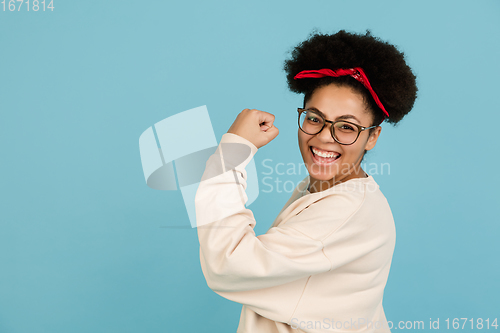 Image of African-american woman\'s portrait isolated on blue studio background with copyspace