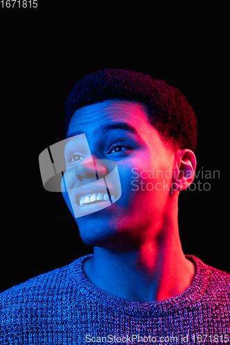 Image of African-american man\'s portrait isolated on black studio background in multicolored neon light