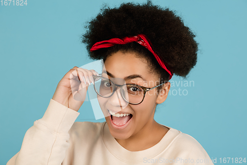 Image of African-american woman\'s portrait isolated on blue studio background with copyspace