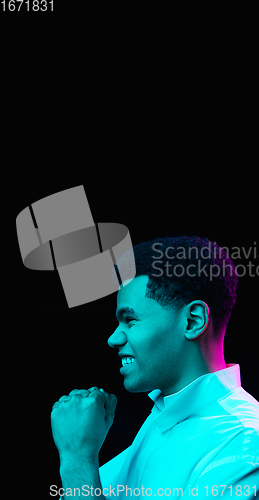 Image of African-american man\'s portrait isolated on black studio background in multicolored neon light