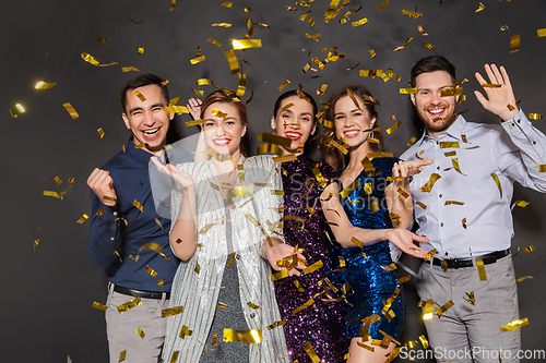 Image of happy friends at party under confetti over black