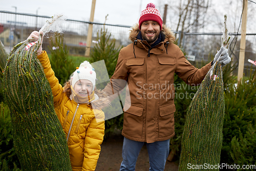 Image of happy family buying christmas tree at market