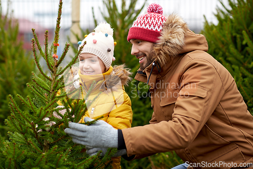 Image of happy family choosing christmas tree at market