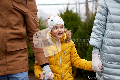 Image of happy family choosing christmas tree at market