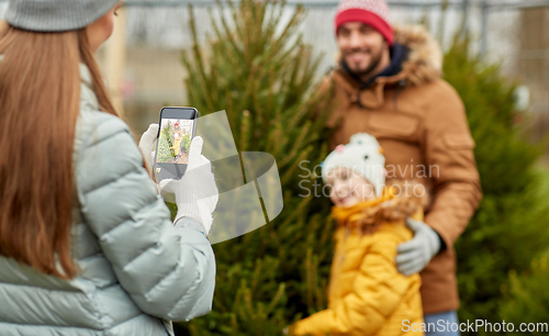 Image of family taking picture of christmas tree at market