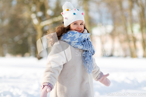 Image of happy little girl in winter clothes outdoors