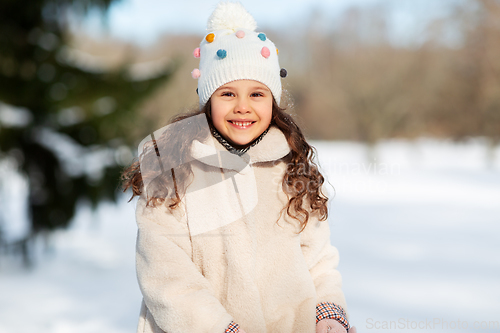 Image of happy little girl in winter clothes outdoors