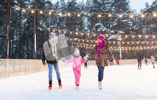 Image of happy family at outdoor skating rink in winter