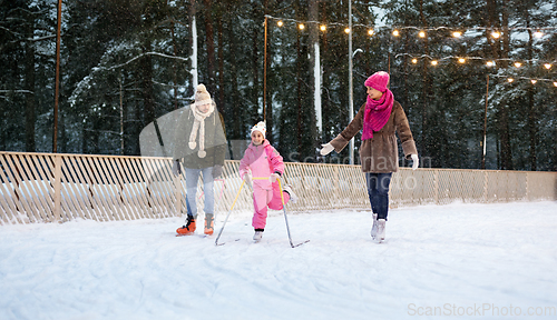 Image of happy family at outdoor skating rink in winter