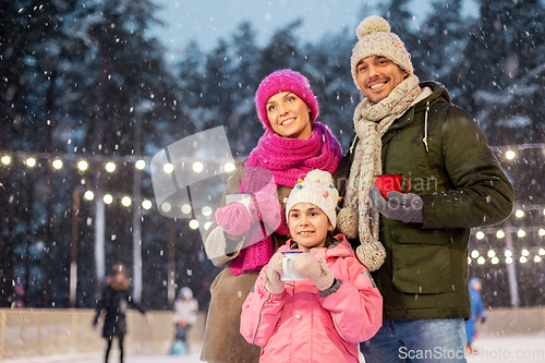 Image of happy family drinking hot tea on skating rink