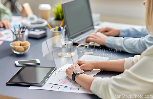 Image of hands with mockup working on ui design at office