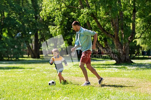 Image of father with little son playing soccer at park