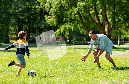 Image of father with little son playing soccer at park