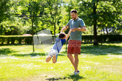 Image of happy father with son playing in summer park