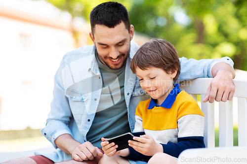 Image of father and son with smartphone at park