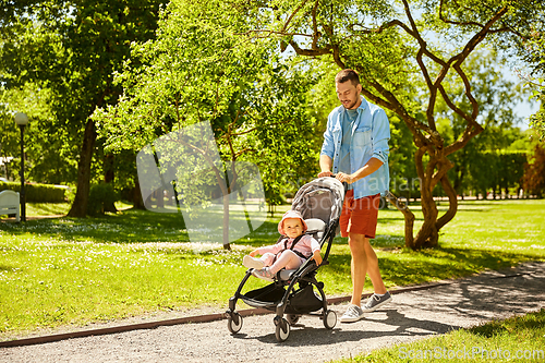 Image of happy father with child in stroller at summer park