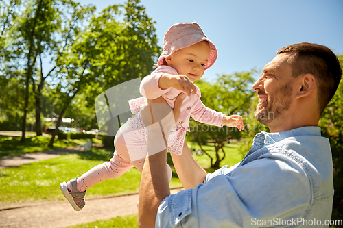 Image of happy father with baby daughter at summer park