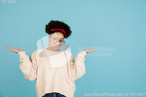 Image of African-american woman\'s portrait isolated on blue studio background with copyspace