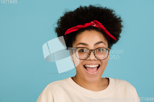 Image of African-american woman\'s portrait isolated on blue studio background with copyspace