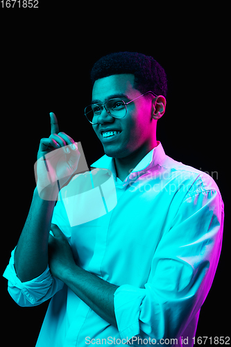 Image of African-american man\'s portrait isolated on black studio background in multicolored neon light