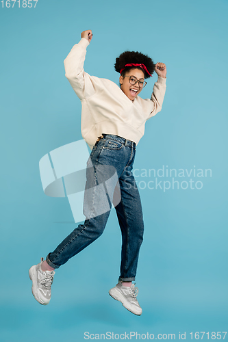 Image of African-american woman\'s portrait isolated on blue studio background with copyspace