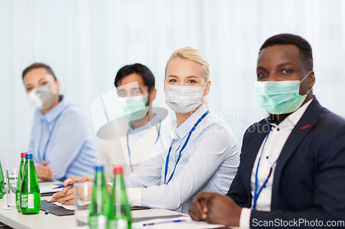 Image of business people in masks at conference