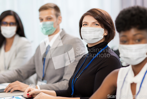 Image of business people in masks at conference