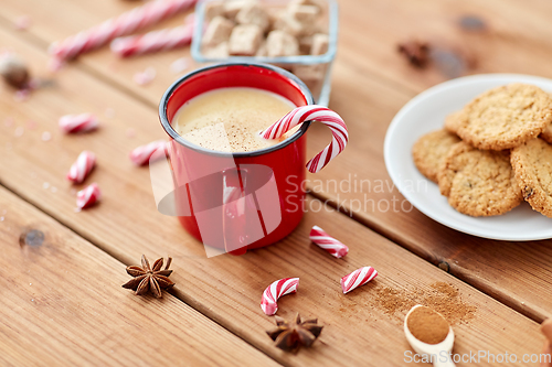 Image of cup of eggnog with candy cane, cookies and sugar