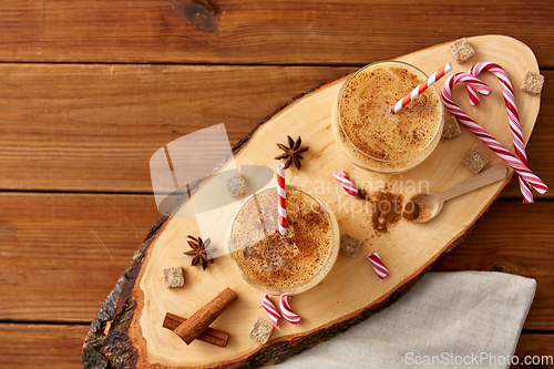 Image of glasses of eggnog, ingredients and spices on wood