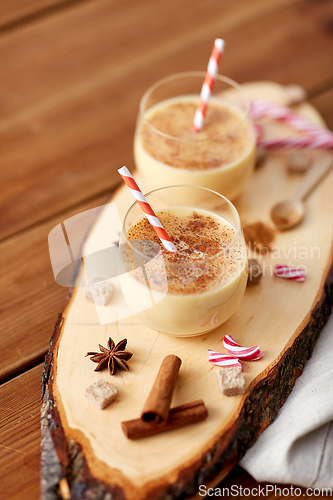 Image of glasses of eggnog, ingredients and spices on wood