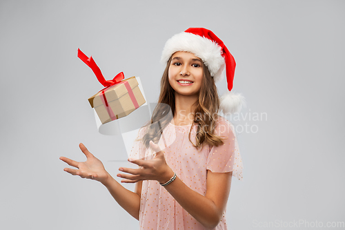 Image of teenage girl in santa hat with christmas gift