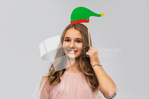Image of happy teenage girl with santa helper hat accessory