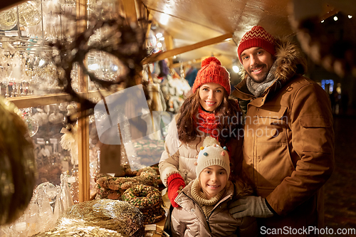 Image of happy family at christmas market in city