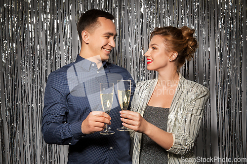 Image of happy couple toasting champagne glasses at party